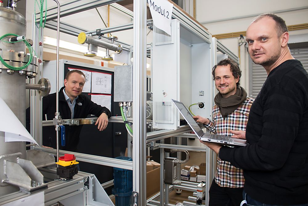 Speicher: Carsten Tietze, Samuel Brinnig und Martin Steiner vom WTZ Roßlau (v.l.) stehen am LOHC Wasserstoffspeicher, der gerade aufgebaut wird. Abbildung: IMG