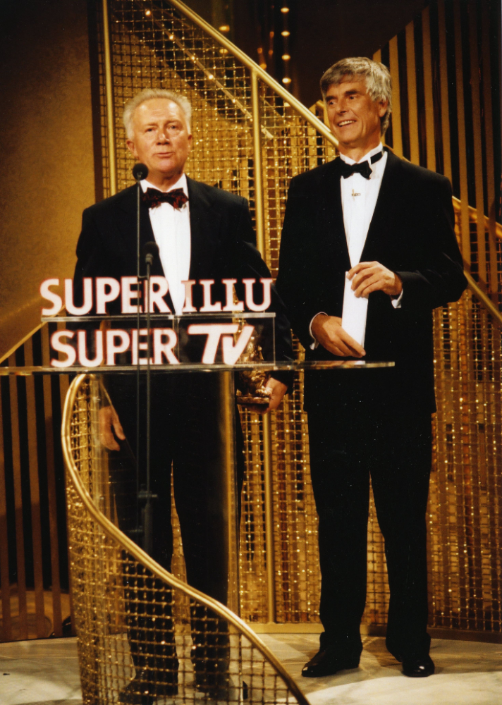 Jähn erhält 1999 den Publikumspreis „Goldene Henne“ für sein Lebenswerk – aus den Händen von Ulf Merbold, der 1983 als zweiter Deutscher ins All flog. Abbildung: SuperIllu