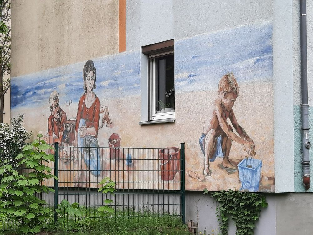 Eine Replikation von Womackas „Am Strand“ als Wandgemälde, gemalt vom Künstler Andreas Bogdain, befindet sich im Heidkampweg in Berlin Baumschulenweg. Abbildung: Urfin7, Wikimedia Commons.