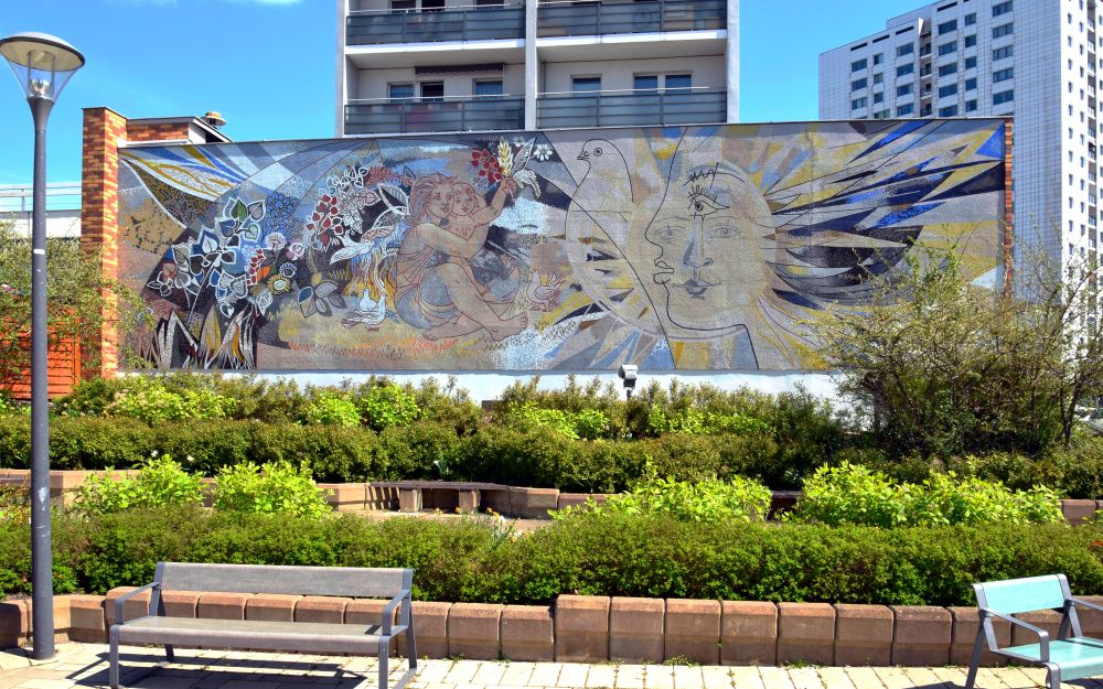 Das Wandmosaik „Frieden“ von Walter Womacka befindet sich an der Marzahner Promenade 45 in Berlin Marzahn. Singlespeedfahrer, Wikimedia Commons.