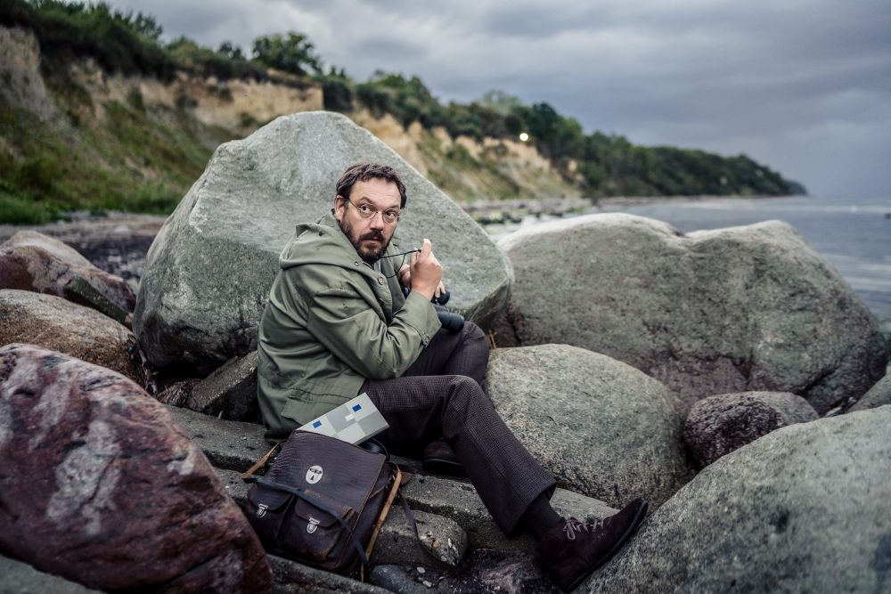 Charly Hübner als Paul bei einer Erkundung an der Ostsee. Auch Klaus Müller erkundete vor seiner Reise die Umgebung und hielt laut Apelt die innerdeutsche Grenze für gefährlicher als die Flucht über die Insel Hiddensee. Abbildung: Sammy Hart, Pandora Film