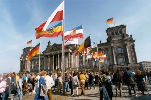 Am 3. Oktober 1990 wurden vor dem Reichstagsgebäude die Fahnen aller Bundesländer Deutschlands aufgestellt. 36 Jahre später hat das Projekt „DNA des Ostens” online zu Ost-West-Unterschieden befragt. Abbildung: Thomas Uhlemann, Das Bundesarchiv, Wikimedia Commons